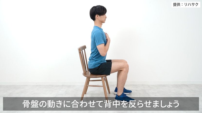 座ったままの胸椎伸展：胸に手を当て、骨盤の動きに合わせて背中を反らす