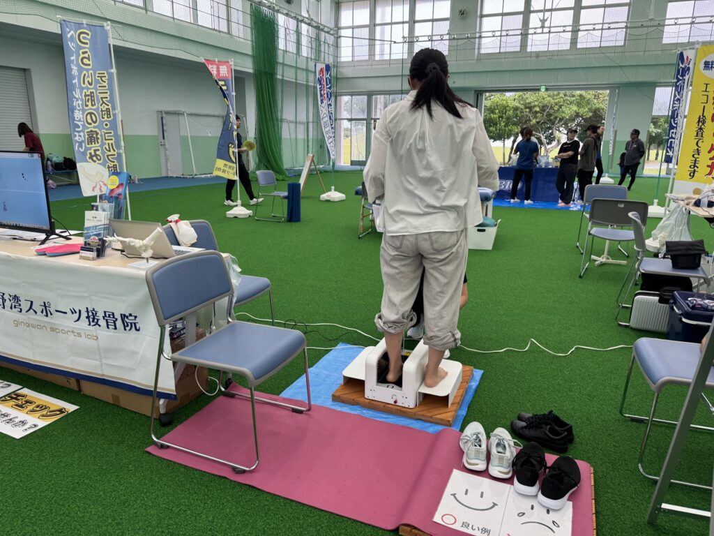 宜野湾スポーツ接骨院の相談ブースで3D足形測定を受ける来場者