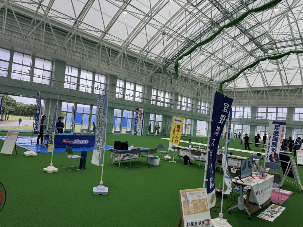 会場に出展した宜野湾スポーツ接骨院のブースと会場のようす